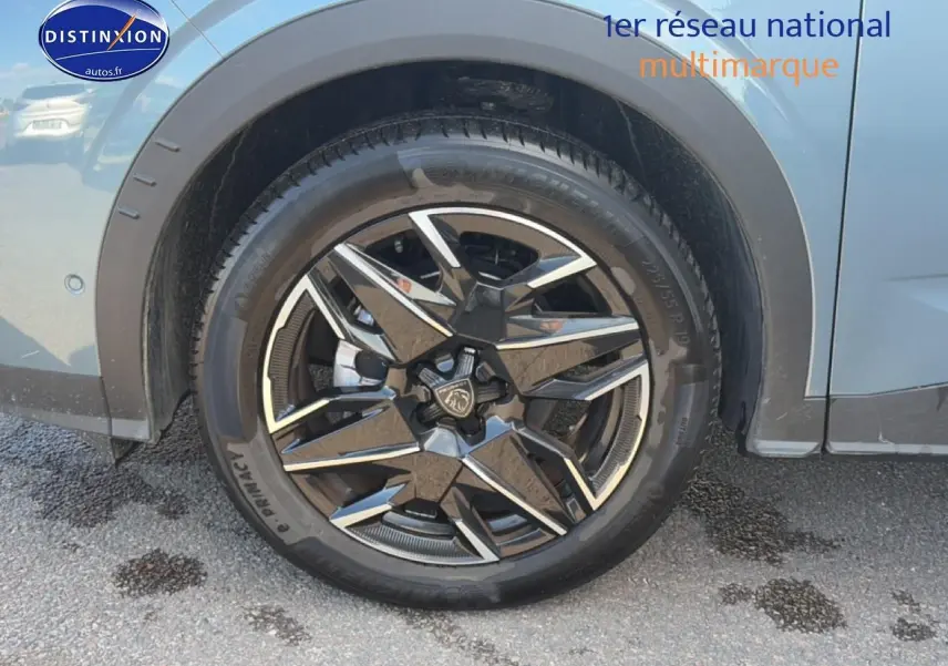 Gros plan sur la roue arrière droite d’un Peugeot 3008 bleu 2025 avec jante alu noire et argentée design.