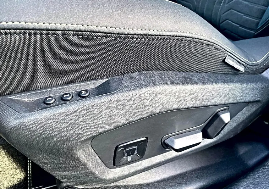 Détail des commandes de réglage électrique du siège avant gauche noir du Peugeot 5008 Hybrid 145 GT 2025.