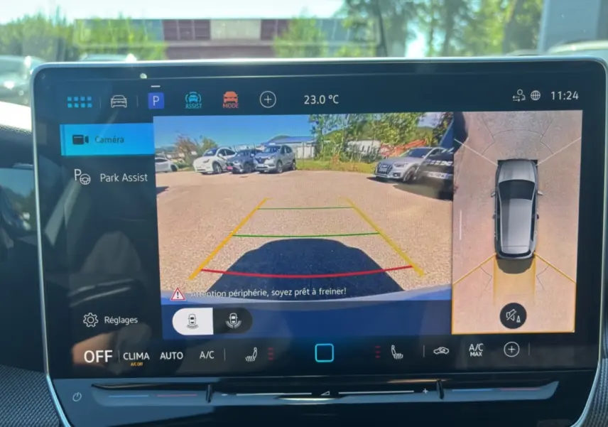 Écran tactile intérieur affichant la caméra 360° et l'aide au stationnement d'une Volkswagen Golf blanche oryx.