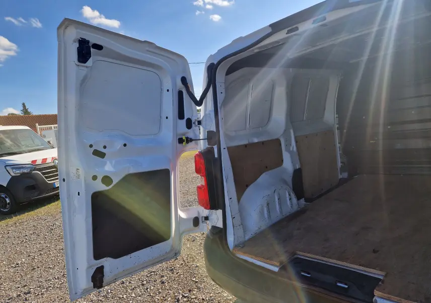 Vue arrière ouverte du Peugeot Expert Fourgon blanc 2020 montrant l'espace de chargement vide avec panneaux en bois.