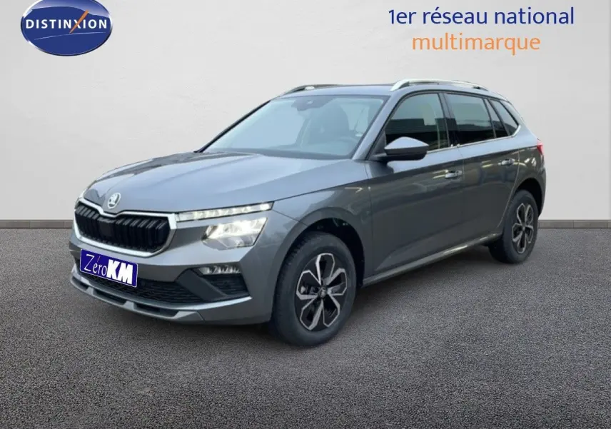 Vue 3/4 avant droite d'un Skoda Kamiq gris graphite métal avec jantes alliage et calandre noire distinctive.