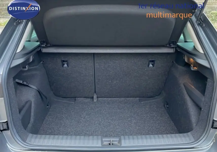 Coffre ouvert vu de l'arrière d'un Skoda Kamiq gris graphite métal, montrant un espace de chargement propre et spacieux.