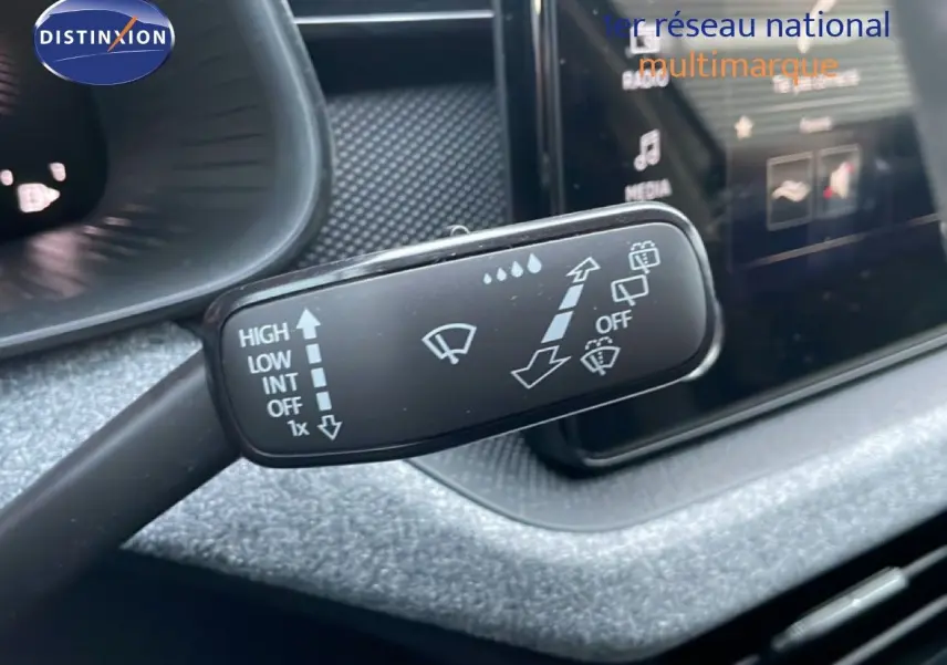 Gros plan sur la commande d’essuie-glace du Skoda Kamiq 2025, intérieur gris graphite avec écran tactile en arrière-plan.