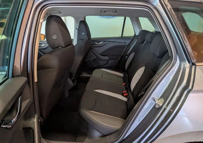 Vue intérieure côté gauche des sièges arrière d'un Skoda Kamiq gris graphite, avec sellerie tissu noir et gris.