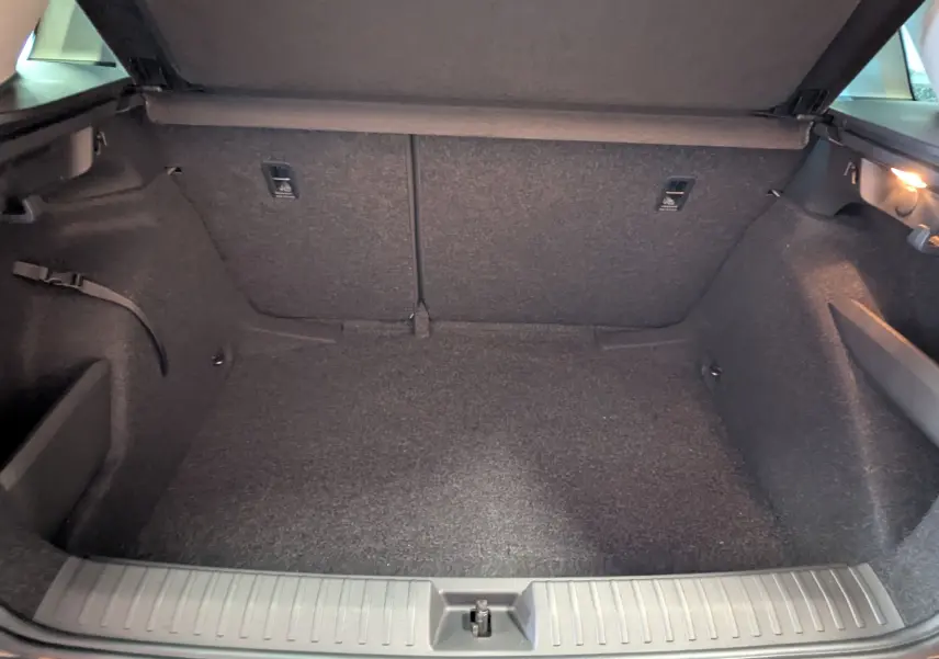 Coffre ouvert d’un Skoda Kamiq gris graphite, vue intérieure montrant l’espace de rangement et l’éclairage latéral droit.