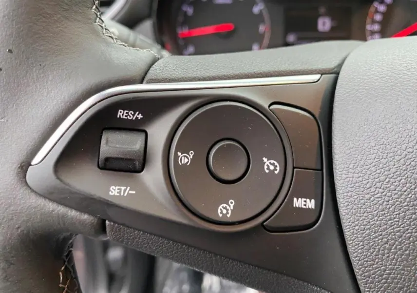Gros plan sur les commandes de régulateur de vitesse au volant cuir de l'Opel Crossland 2022.