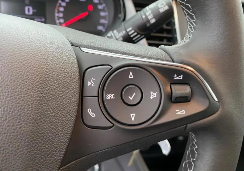 Gros plan sur les commandes du volant cuir multifonction de l’Opel Crossland 2022, version essence gris métallisé.
