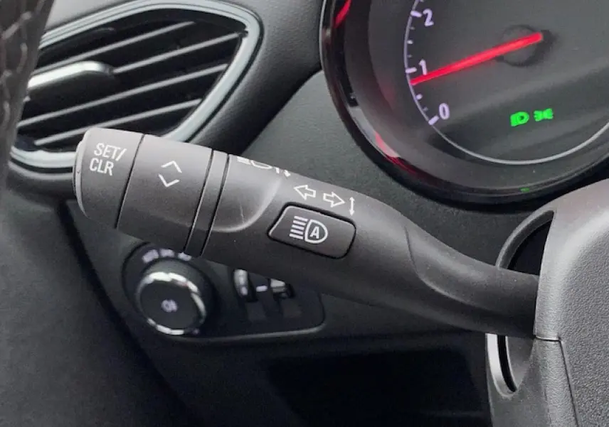 Gros plan sur la commande de clignotant et régulateur du tableau de bord gris foncé de l’Opel Crossland 2022.