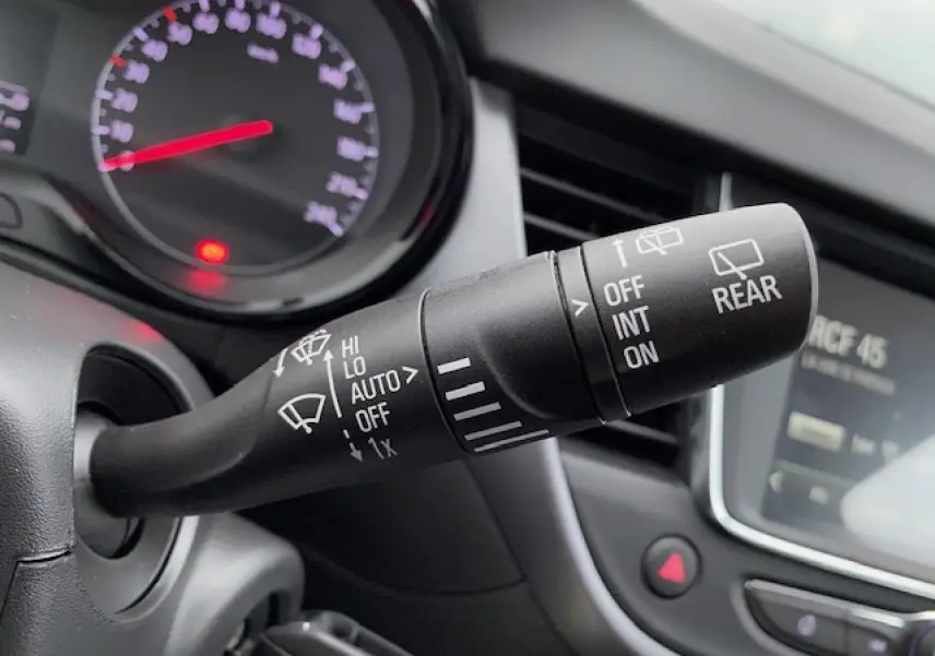 Gros plan sur la commande des essuie-glaces à gauche du volant dans l’habitacle d’un Opel Crossland gris métallisé 2022.
