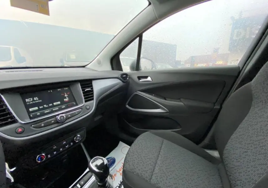 Vue intérieure côté passager de l’Opel Crossland gris, avec tableau de bord et écran tactile multimédia visible.