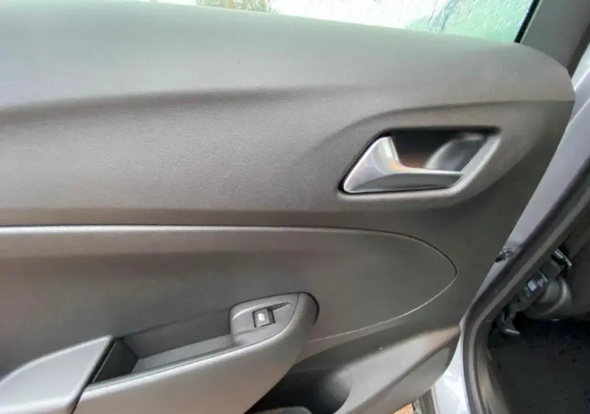 Vue rapprochée de la porte avant droite grise métallisée de l’Opel Crossland 2022 avec poignée et bouton de verrouillage.
