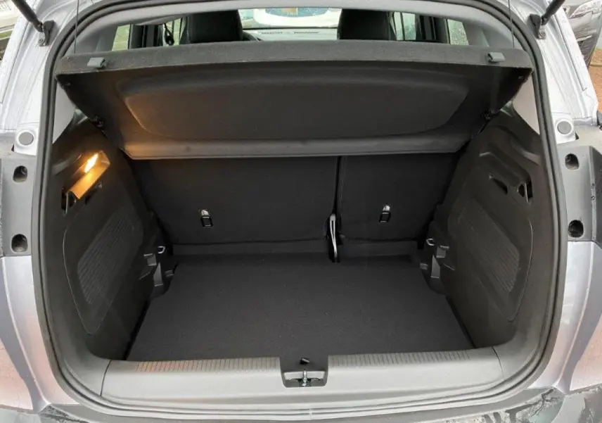 Coffre ouvert d’un Opel Crossland gris métallisé 2022, vue arrière montrant l’espace de chargement vide et l’éclairage intérieur.