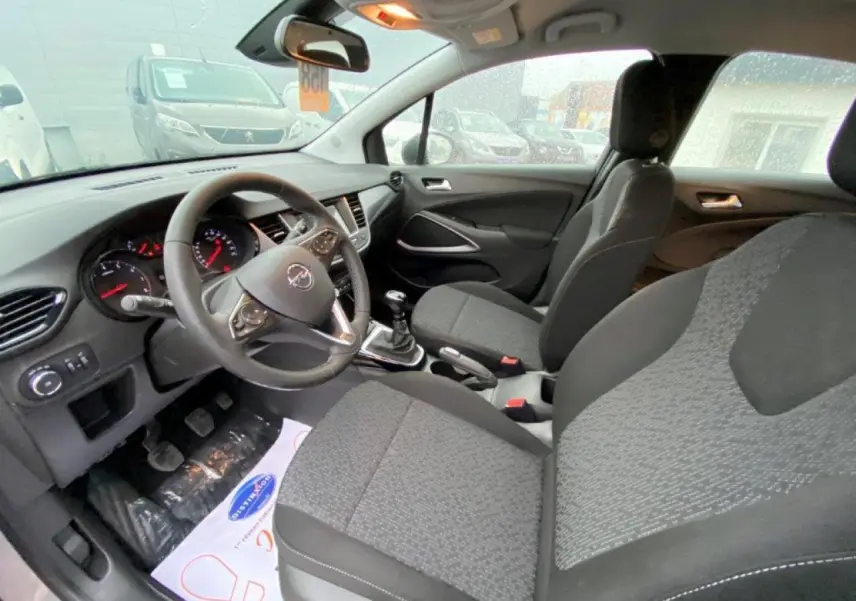 Intérieur d’Opel Crossland gris métallisé vu côté conducteur, volant cuir multifonction et boîte manuelle visibles.