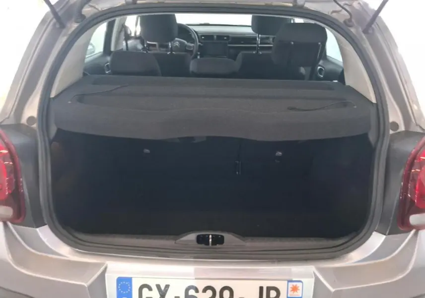 Coffre ouvert d'une Citroën C3 gris foncé 2024, vue arrière montrant l'intérieur et la plage arrière.