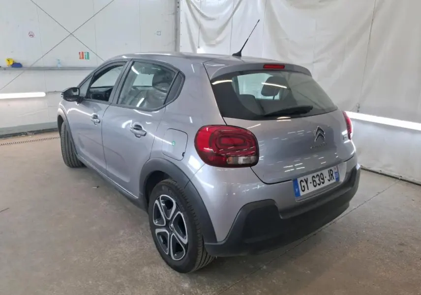Vue 3/4 arrière droite d'une Citroën C3 gris foncé 2024 avec feux arrière arrondis et jantes spécifiques.