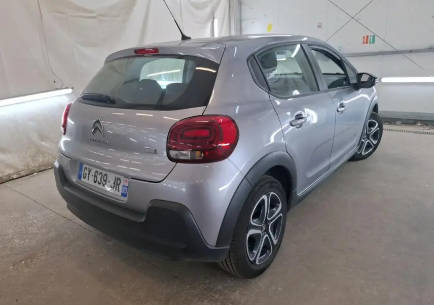 Vue 3/4 arrière droite d'une Citroën C3 gris foncé 2024 avec feux arrière arrondis et jantes distinctives.