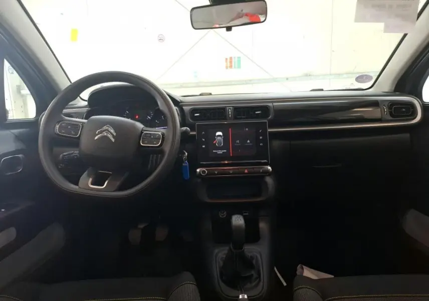 Intérieur de la Citroën C3 2024 gris foncé, vue de face sur le tableau de bord avec écran tactile et volant multifonction.