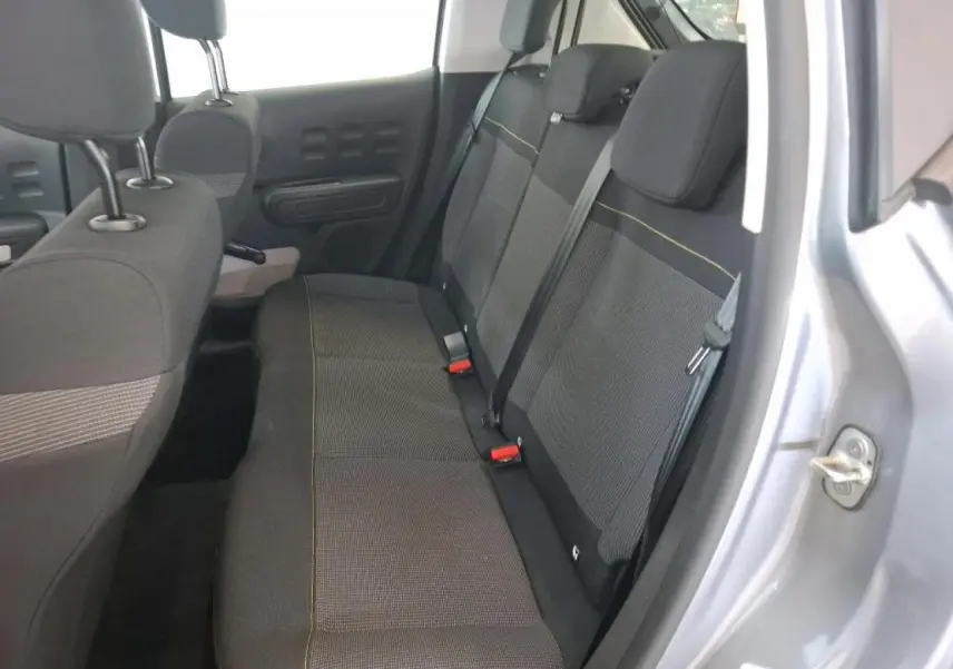 Vue intérieure côté droit sur la banquette arrière grise foncée de la Citroën C3 2024 avec surpiqûres jaunes visibles.