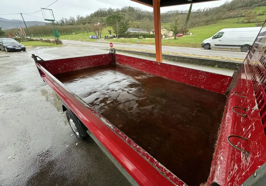 Vue rapprochée de la benne rouge du Citroën Jumper III 2019, montrant les ridelles latérales et arrière sous abri.