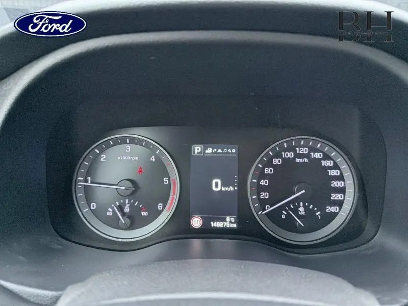 Vue rapprochée du tableau de bord d'un Hyundai Tucson 2018, affichage digital au centre et compteurs analogiques.