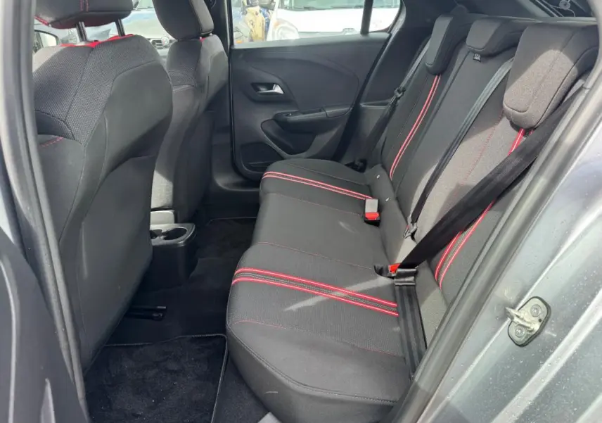 Vue intérieure côté droit des sièges arrière noirs avec surpiqûres rouges d'une Opel Corsa gris clair 2022 GS Line.