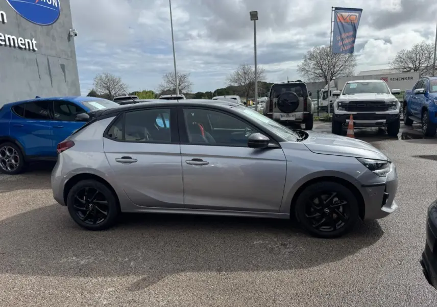 Opel Corsa gris clair vue de profil côté gauche, jantes noires et ligne GS Line visible, stationnée en extérieur.