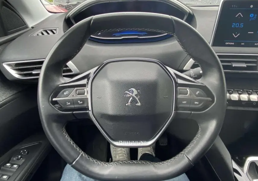 Vue intérieure centrée sur le volant compact noir du Peugeot 3008 avec tableau de bord numérique et écran tactile.
