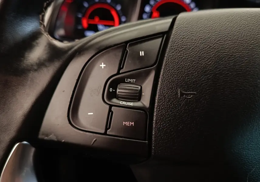 Gros plan sur les commandes de régulateur de vitesse du volant en cuir noir du DS5 BlueHDi 180 Automatique Chic.