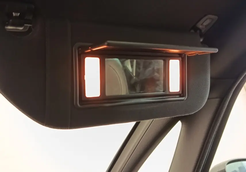 Miroir de courtoisie éclairé sur pare-soleil intérieur côté conducteur d'une DS5 noire, vue rapprochée.