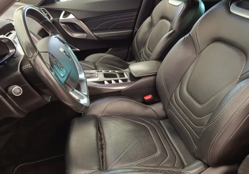 Vue intérieure côté conducteur du DS5 2018, sièges et volant en cuir noir avec console centrale élégante.