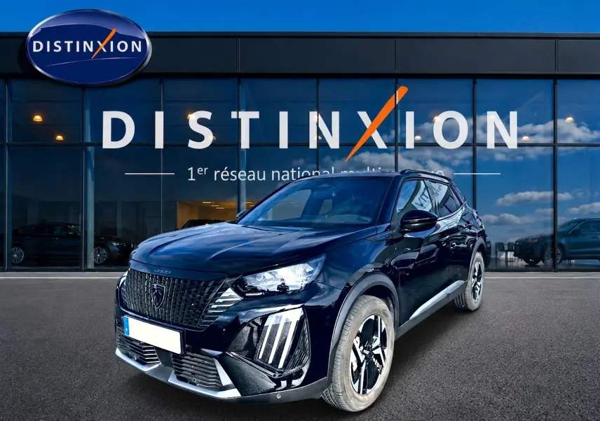 Peugeot 2008 noir en 3/4 avant droit, avec calandre distinctive et jantes alu bicolores devant showroom Distinxion.