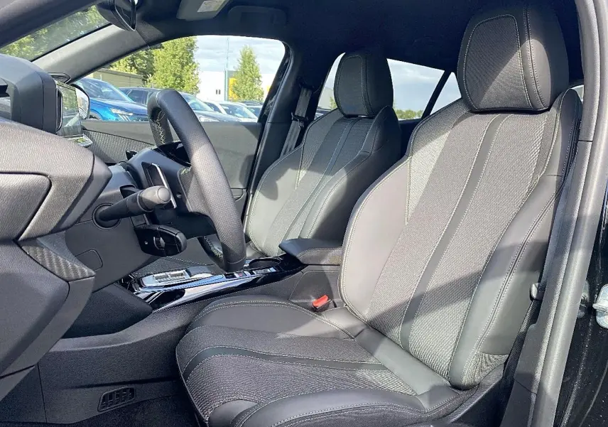 Vue intérieure côté conducteur du Peugeot 2008 1.2 hybrid 145 GT noir, sièges en tissu et cuir avec volant multifonction.