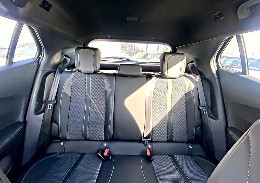 Vue arrière intérieure sur la banquette arrière noire avec surpiqûres claires du Peugeot 2008 1.2 hybrid 145 GT.