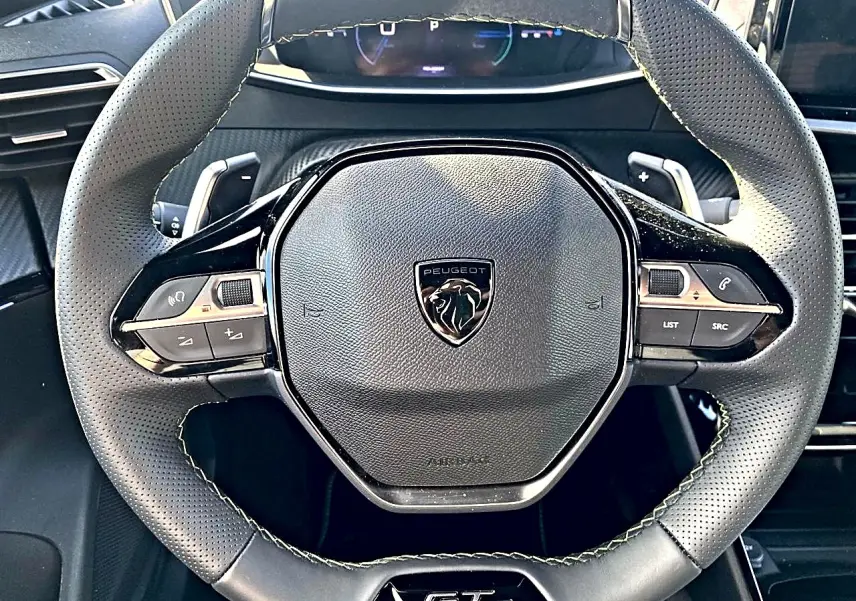Vue rapprochée du volant cuir noir perforé avec logo Peugeot et badge GT au centre, intérieur du Peugeot 2008 2025.