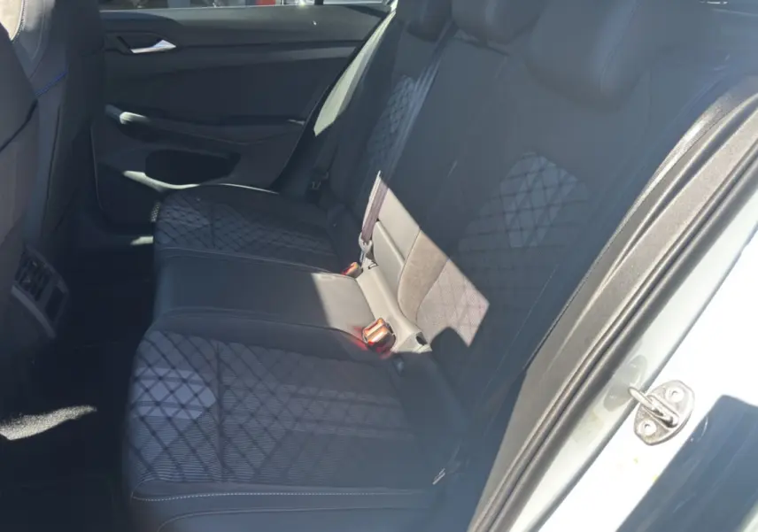 Vue intérieure côté droit sur la banquette arrière en tissu noir à motifs géométriques d’une Volkswagen Golf blanc oryx.