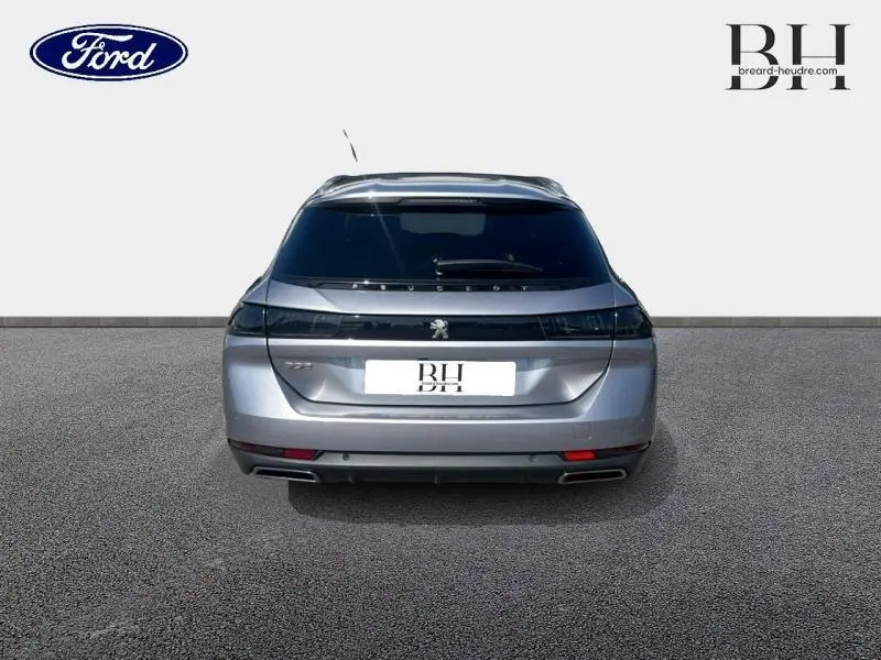 Vue arrière d'une Peugeot 508 SW gris Artense avec feux arrière LED et double sortie d'échappement intégrée.