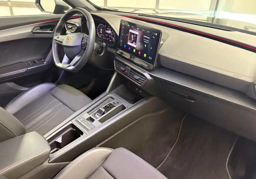 Intérieur avant droit du CUPRA Formentor 2023 avec tableau de bord noir, volant multifonction et écran tactile central.