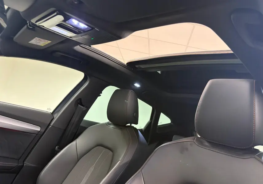 Intérieur du CUPRA Formentor 2023 avec toit ouvrant panoramique et sièges en cuir noir vus côté gauche.