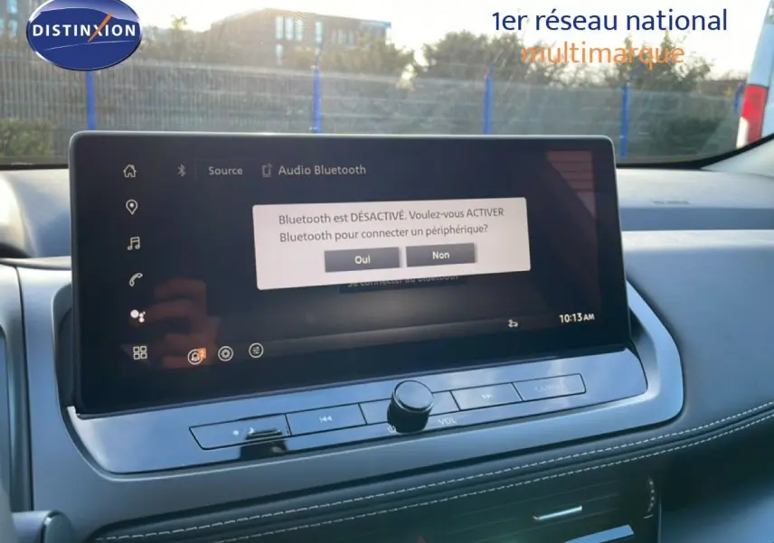 Écran tactile central du Nissan Qashqai 2025 en gros plan, affichant un message Bluetooth désactivé, intérieur gris.