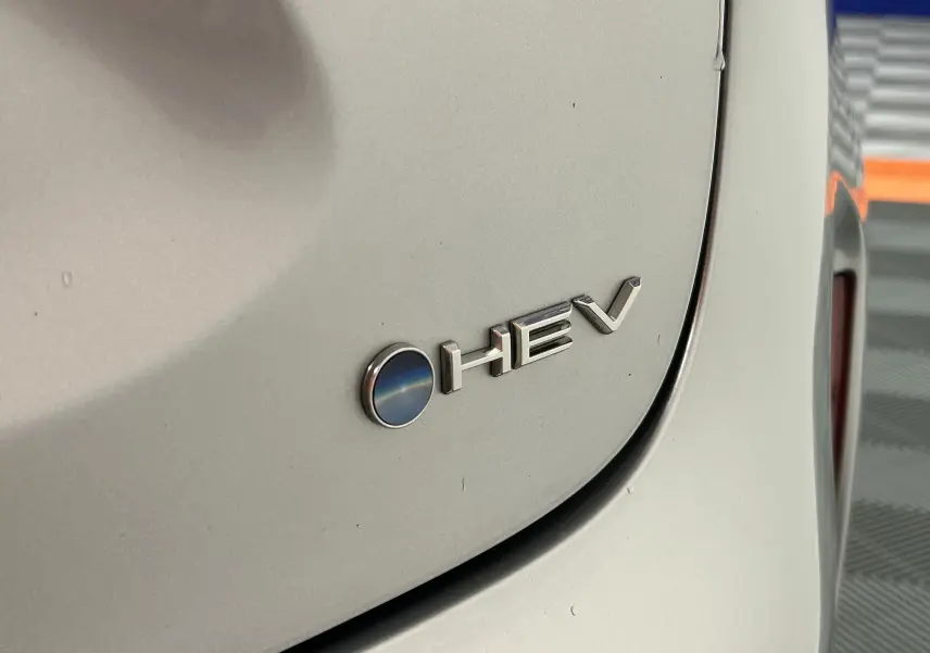 Gros plan sur l'arrière gris minéral d'une Toyota Yaris Cross 116h avec le badge HEV visible à droite.