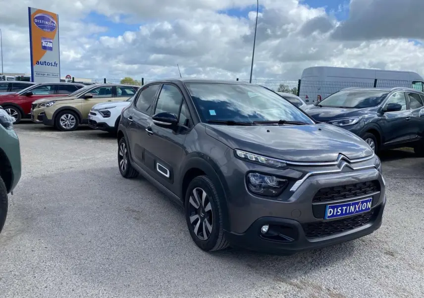 Citroën C3 gris platinium en 3/4 avant droit, avec toit bi-ton noir et jantes alliage diamantées visibles.