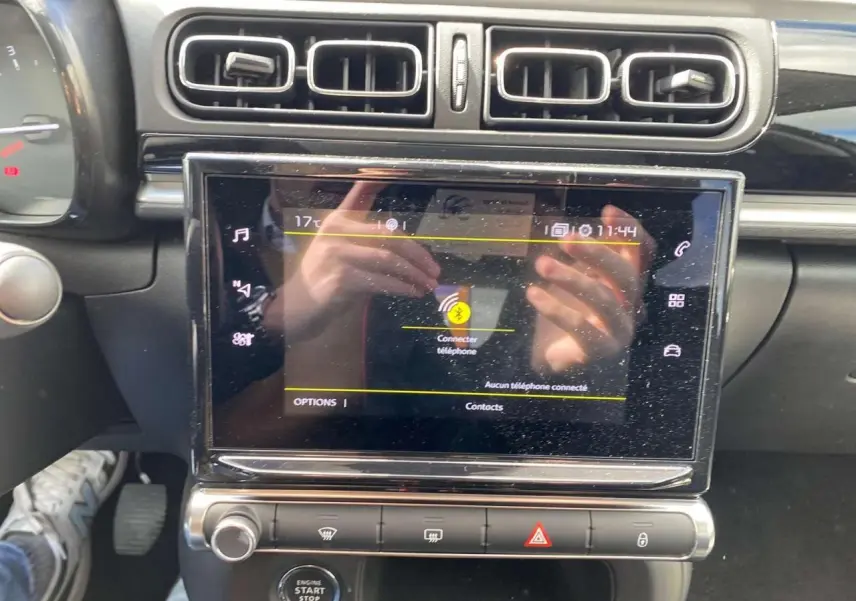 Vue rapprochée de la console centrale de la Citroën C3 2021, écran tactile avec interface Bluetooth et commandes climatisation.