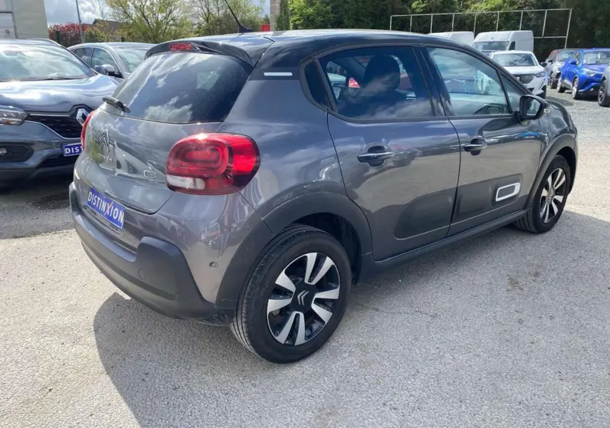 Vue 3/4 arrière droite d'une Citroën C3 gris platinium avec toit noir et jantes alliage distinctives.