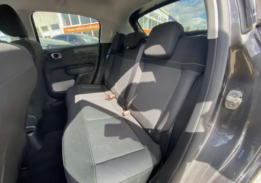 Vue intérieure côté arrière droit de la Citroën C3 gris platinium, montrant la banquette arrière et la portière ouverte.