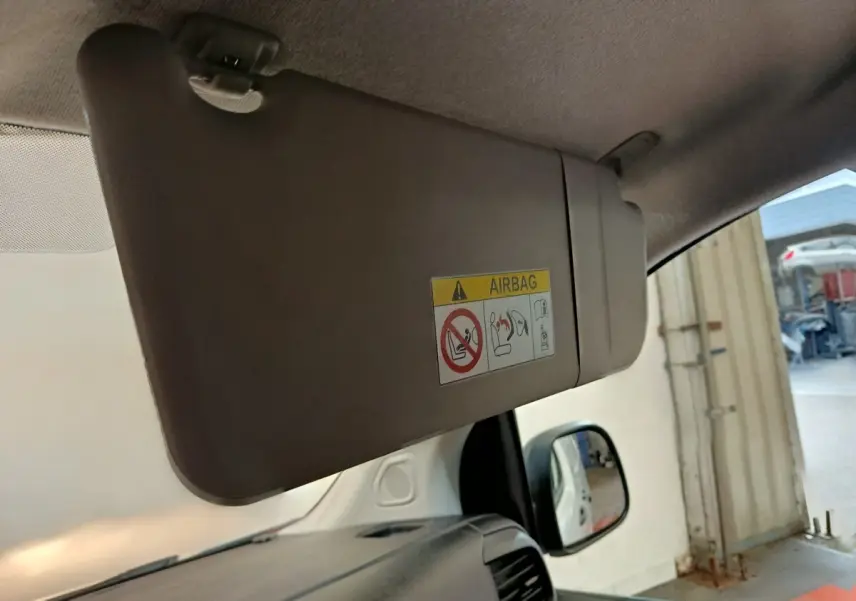Pare-soleil côté conducteur beige avec étiquette airbag, vue intérieure avant droite du Peugeot Expert Fourgon blanc.