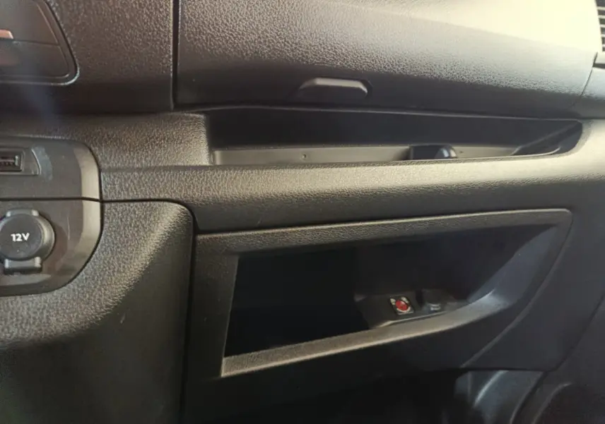 Détail de la console centrale noire côté passager du Peugeot Expert Fourgon blanc, avec prise 12V visible.