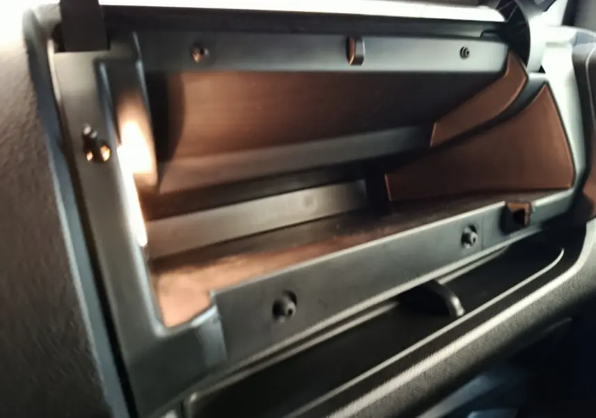 Gros plan sur la boîte à gants ouverte du Peugeot Expert Fourgon blanc, intérieur noir avec éclairage intérieur visible.