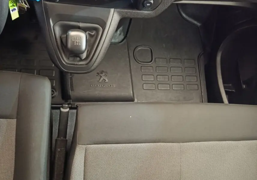 Vue intérieure centrée sur la console centrale et levier de vitesses manuelle du Peugeot Expert Fourgon, sièges gris.
