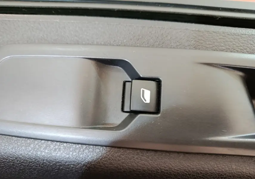 Gros plan sur le bouton de commande de la porte coulissante intérieure du Peugeot Expert Fourgon blanc, version 2023.