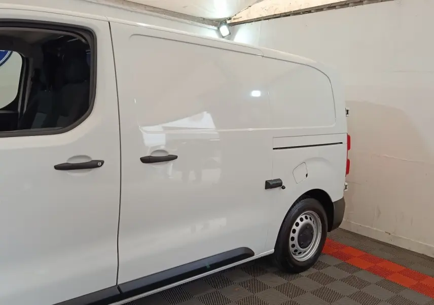 Vue de profil côté droit d’un Peugeot Expert Fourgon blanc, avec portes latérales pleines et jantes acier.